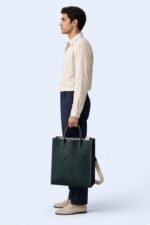 FRANE, cabas en cuir vert Cèdre — vue de profil, fond bleu